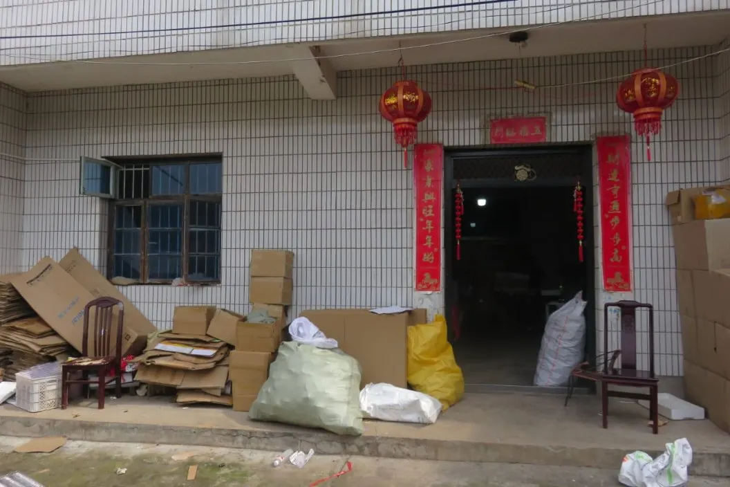 Factory entrance with red lanterns, stacked cardboard boxes and bags of materials
