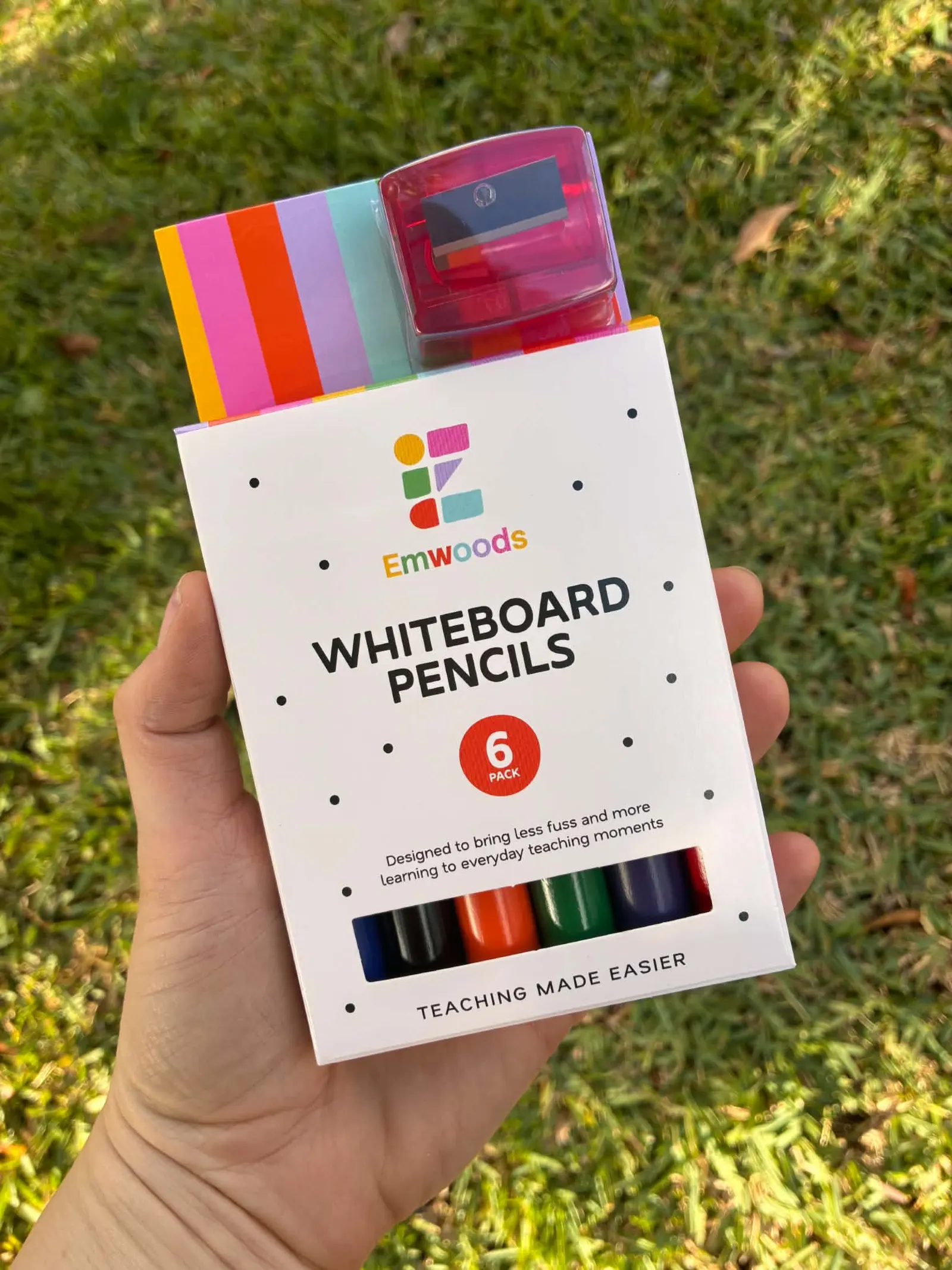 A hand holding a six pack of Emwoods whiteboard pencils from the brand's first full production run