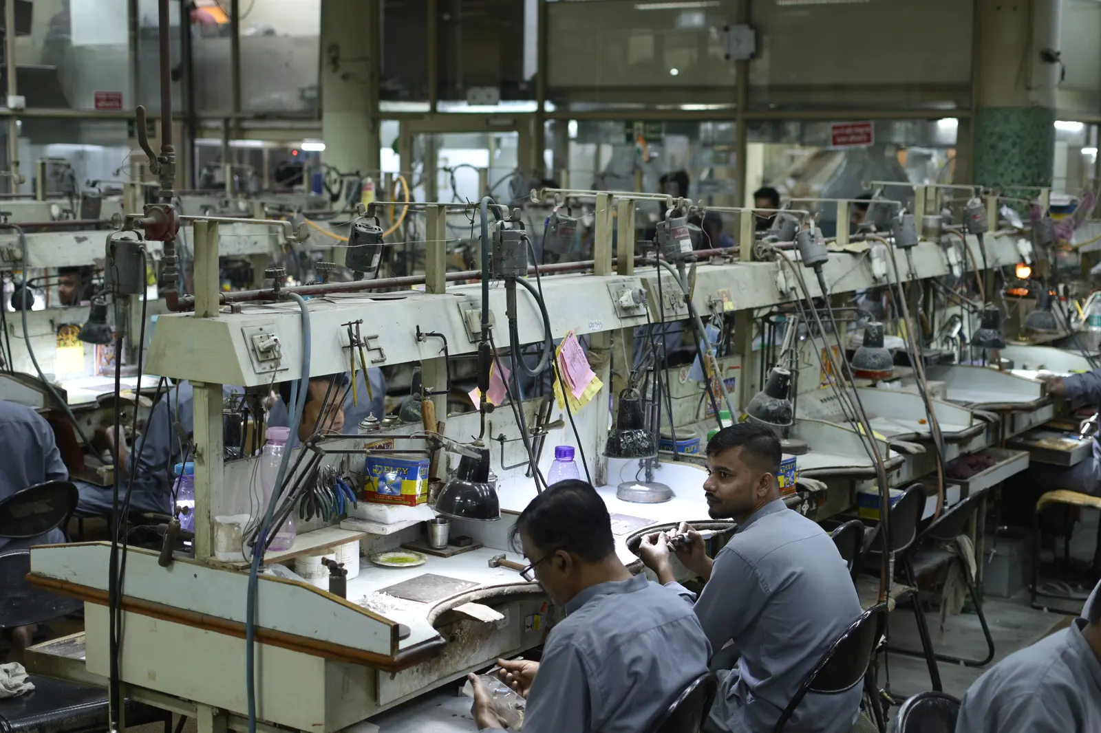Rows of sewing machines and workers on a garment factory production floor